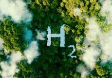Image from above of an H with a subscript of 2 made of water, surrounded by trees