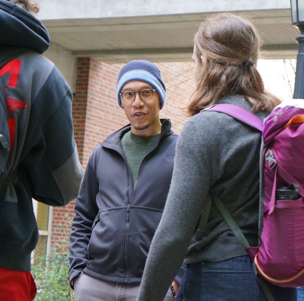Professor Wilkerson-Hill smiles while speaking with two students.