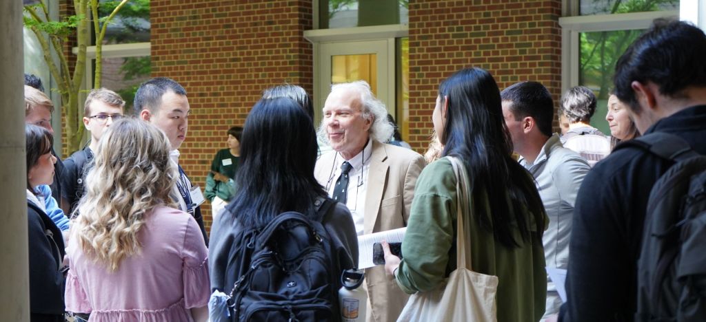 Professor Pielak stands in the middle of a group of students.