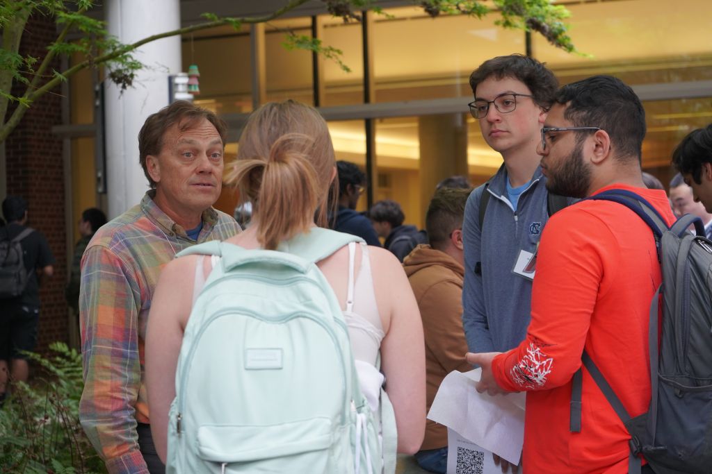 Professor Meyers talks with a group of students. He looks slightly surprised.