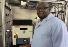 Oluwaseun Oyetade, lead author of the paper and a postdoctoral research associate, stands beside a plasma-enhanced chemical vapor deposition system (PECVD) for thin-film growth of carbon nanostructures which have specific properties for use in various applications, such as electronics, photovoltaics and sensors.